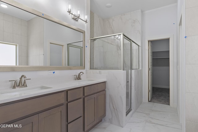 full bath featuring a marble finish shower, marble finish floor, double vanity, and a sink
