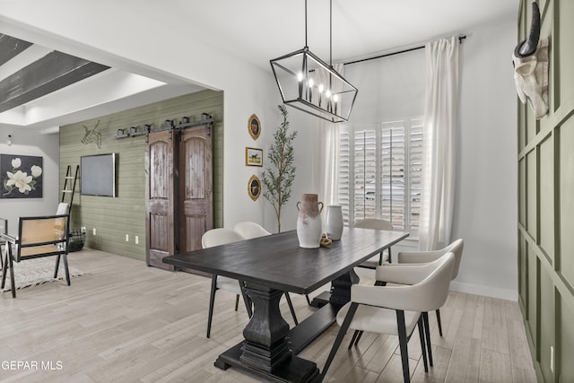 13352 Eton Ct, El Paso, TX 79928 - dining room with a barn door, light wood-style floors, a chandelier, and baseboards