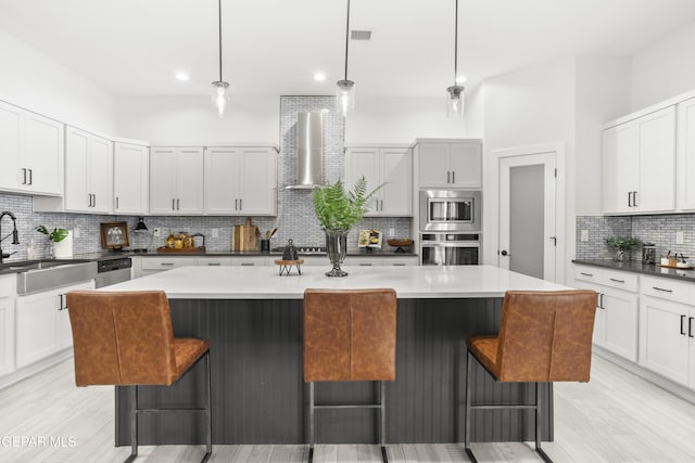 13352 Eton Ct, El Paso, TX 79928 - kitchen featuring stainless steel appliances, wall chimney range hood, a sink, decorative backsplash, and a kitchen bar