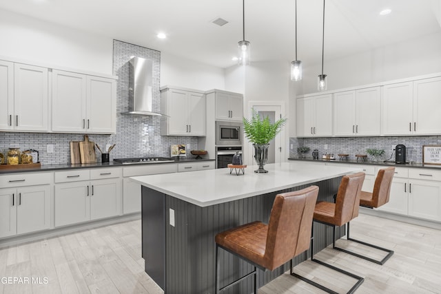 13352 Eton Ct, El Paso, TX 79928 - kitchen featuring stainless steel appliances, wall chimney exhaust hood, tasteful backsplash, a center island, and a kitchen breakfast bar