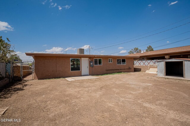 420 Kelvin Ave, El Paso, TX 79915 - rear view of house featuring stucco siding, a gate, fence, and a storage unit