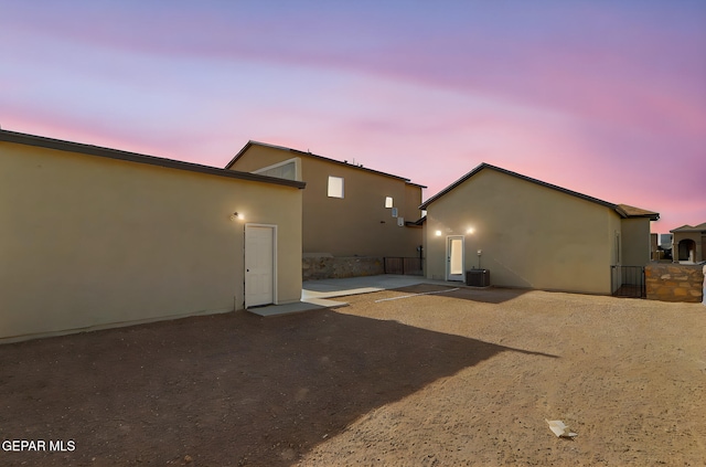 14296 Chris Zingo Ln, El Paso, TX 79928 - back of property at dusk with stucco siding, a patio, and cooling unit