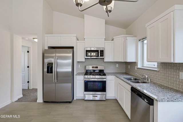14296 Chris Zingo Ln, El Paso, TX 79928 - kitchen with decorative backsplash, appliances with stainless steel finishes, a sink, and vaulted ceiling
