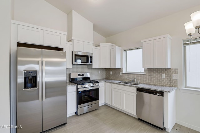 14296 Chris Zingo Ln, El Paso, TX 79928 - kitchen featuring a sink, lofted ceiling, backsplash, white cabinetry, and appliances with stainless steel finishes