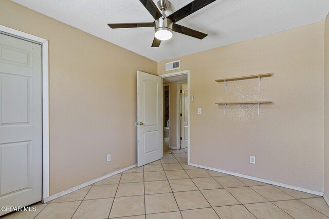 unfurnished bedroom with baseboards, light tile patterned flooring, and ceiling fan