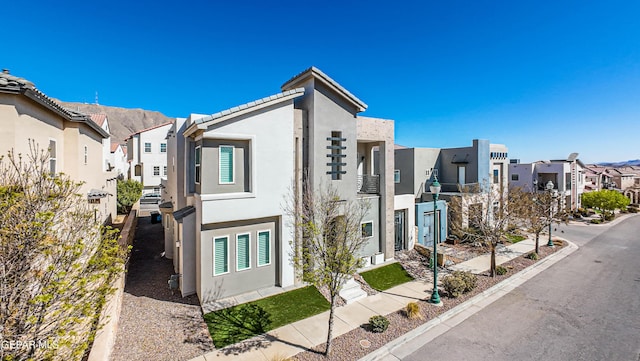 view of property exterior featuring a residential view, stucco siding, and a balcony