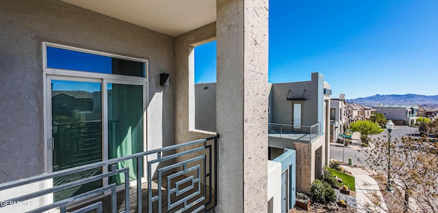 view of side of home featuring stucco siding, a mountain view, and a residential view