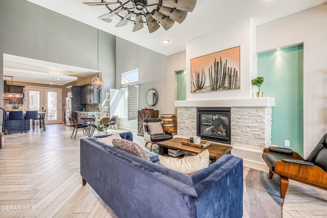 living room with high vaulted ceiling, a ceiling fan, a fireplace, and baseboards
