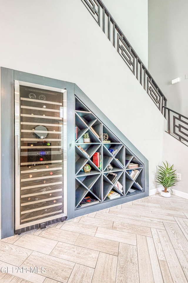 wine area featuring wine cooler and a high ceiling