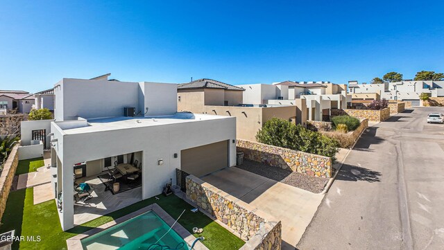 view of front of house featuring a residential view, stucco siding, and a garage