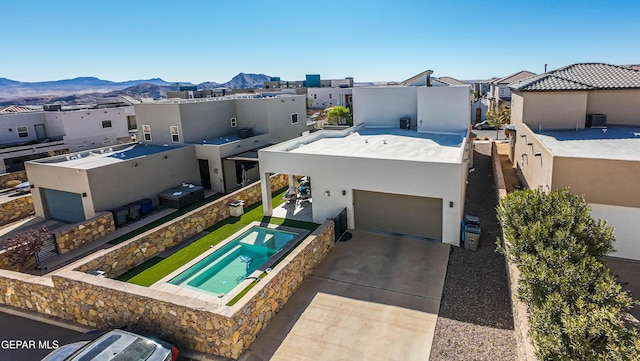rear view of house featuring a residential view, stucco siding, a mountain view, and driveway