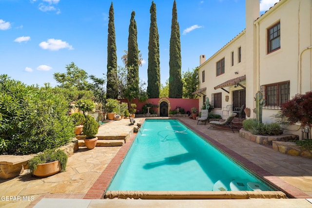swimming pool featuring a patio area and a fenced backyard