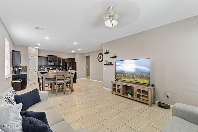living room featuring visible vents, baseboards, wood finish floors, ceiling fan, and recessed lighting