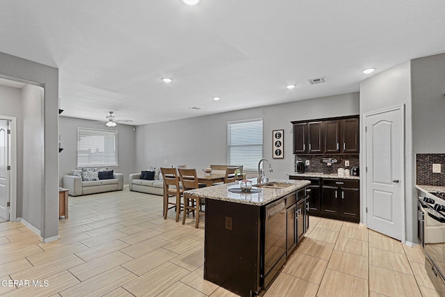 kitchen featuring dishwasher, stove, visible vents, a sink, and tasteful backsplash