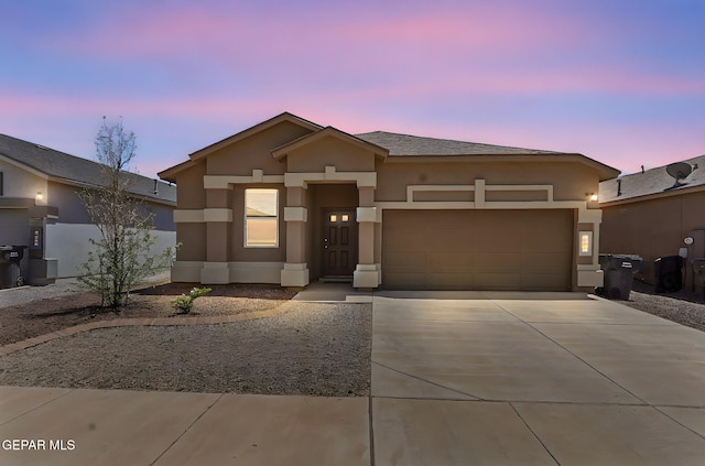 view of front of house with an attached garage, stucco siding, and driveway