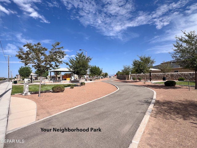 view of road featuring curbs, sidewalks, and street lights