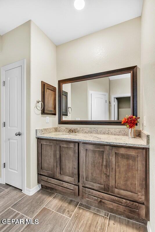14920 Tierra Fortaleza Ave, El Paso, TX 79938 - full bath with baseboards, vanity, and wood finished floors