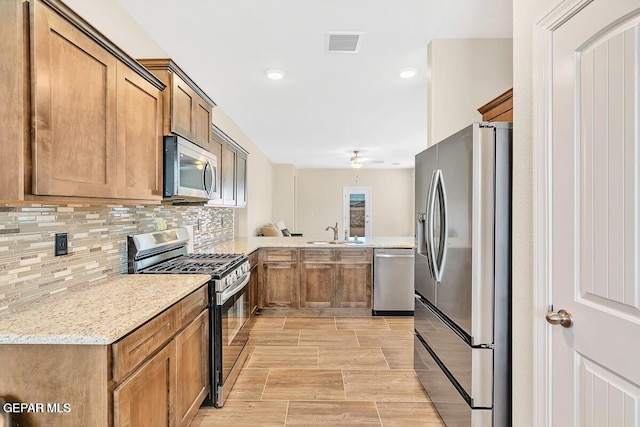 14920 Tierra Fortaleza Ave, El Paso, TX 79938 - kitchen featuring a sink, brown cabinets, visible vents, decorative backsplash, and appliances with stainless steel finishes