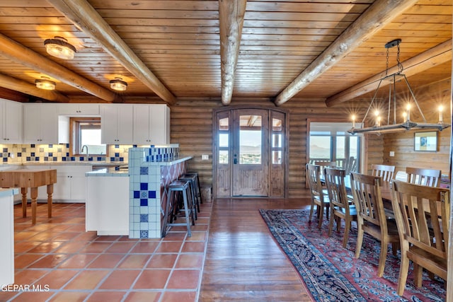 2 Scenic Ridge Rd N, Alpine, TX 99999 - dining room with wooden ceiling, healthy amount of natural light, beamed ceiling, rustic walls, and a chandelier