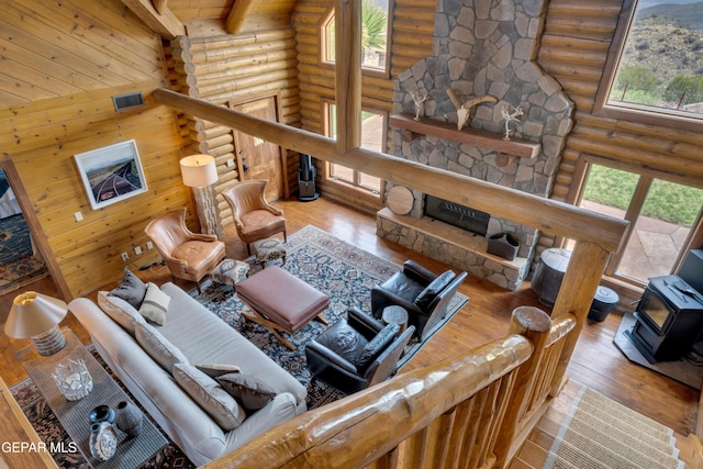 2 Scenic Ridge Rd N, Alpine, TX 99999 - living room with rustic walls, hardwood / wood-style flooring, plenty of natural light, a wood stove, and beamed ceiling