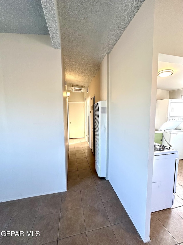 45 S Boone St, El Paso, TX 79905 - hall featuring dark tile patterned flooring, a heating unit, a textured ceiling, visible vents, and washer / dryer