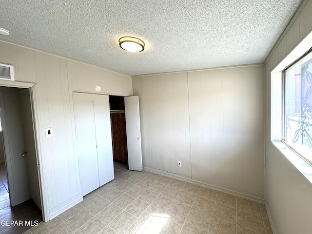 45 S Boone St, El Paso, TX 79905 - unfurnished bedroom with a textured ceiling, a closet, light tile patterned floors, and visible vents