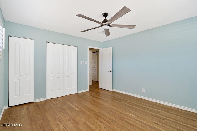 4731 Leeds Ave, El Paso, TX 79903 - unfurnished bedroom with baseboards, ceiling fan, two closets, and wood finished floors