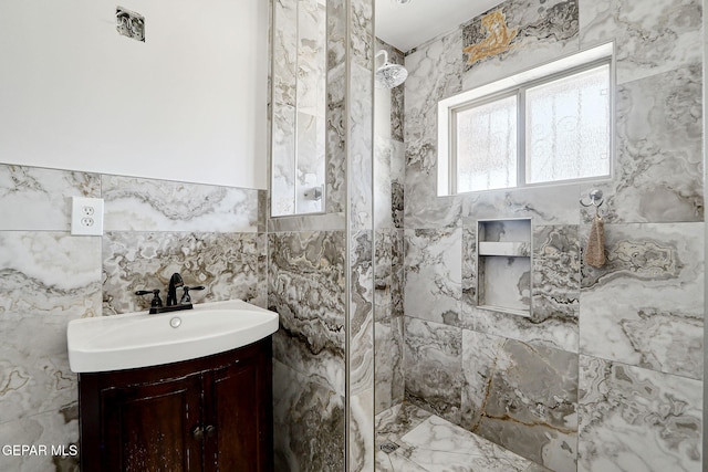 4731 Leeds Ave, El Paso, TX 79903 - bathroom with vanity, tile walls, tiled shower, and marble finish floor