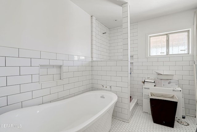 4731 Leeds Ave, El Paso, TX 79903 - bathroom featuring tile patterned floors, tile walls, a freestanding tub, and a tile shower