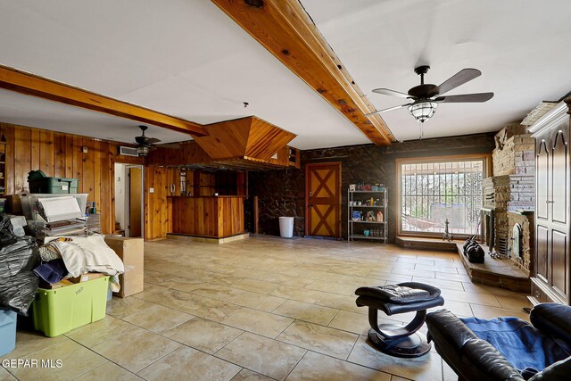 4731 Leeds Ave, El Paso, TX 79903 - living area with a large fireplace, beamed ceiling, wooden walls, and ceiling fan
