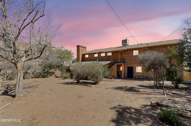 4731 Leeds Ave, El Paso, TX 79903 - back of property at dusk with cooling unit and a chimney