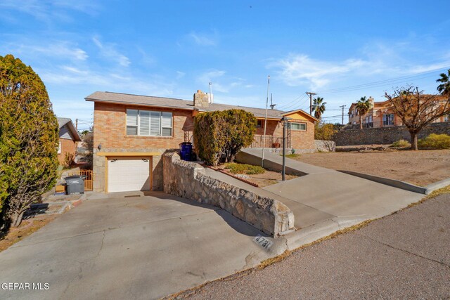 4731 Leeds Ave, El Paso, TX 79903 - ranch-style home with concrete driveway, brick siding, and an attached garage