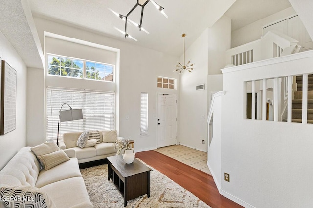 living area with wood finished floors and a towering ceiling