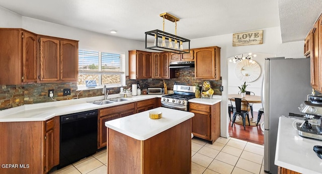 kitchen featuring a sink, appliances with stainless steel finishes, light tile patterned flooring, light countertops, and decorative backsplash