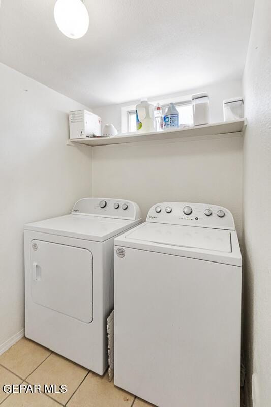 washroom featuring washing machine and clothes dryer and light tile patterned floors