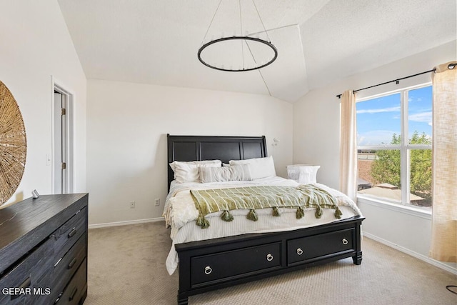 bedroom with vaulted ceiling, light carpet, and baseboards