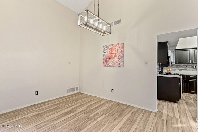 2250 Nancy Mcdonald Dr, El Paso, TX 79936 - unfurnished dining area featuring light wood-style flooring, baseboards, and a chandelier