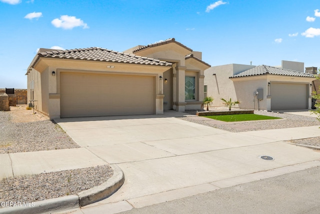 mediterranean / spanish house with concrete driveway, stucco siding, a garage, and a tile roof