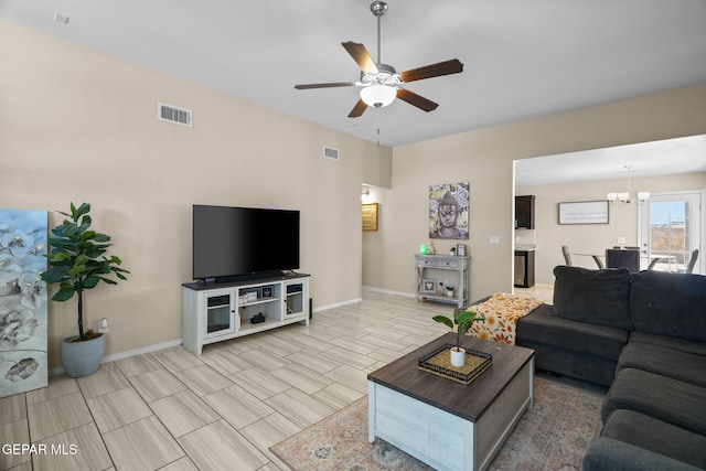 living room with baseboards, visible vents, and ceiling fan with notable chandelier