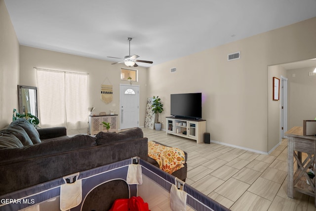 living room featuring a ceiling fan, baseboards, and visible vents