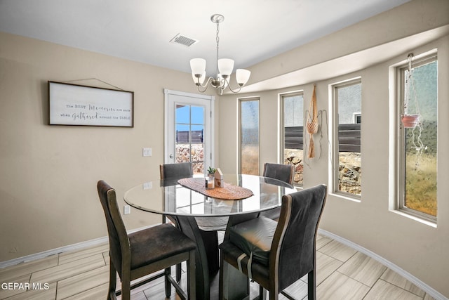 dining area with baseboards, an inviting chandelier, and visible vents