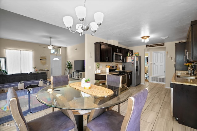 dining room with light tile patterned flooring, visible vents, and ceiling fan with notable chandelier