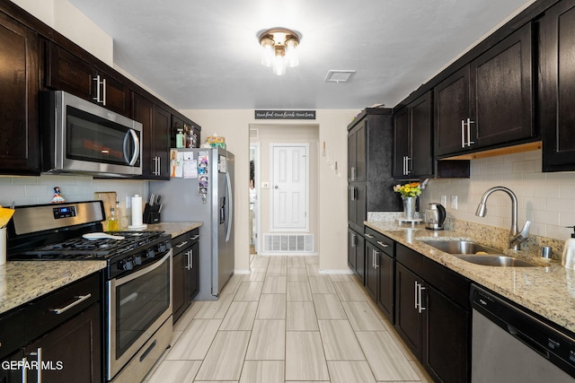 kitchen featuring backsplash, stainless steel appliances, visible vents, and a sink