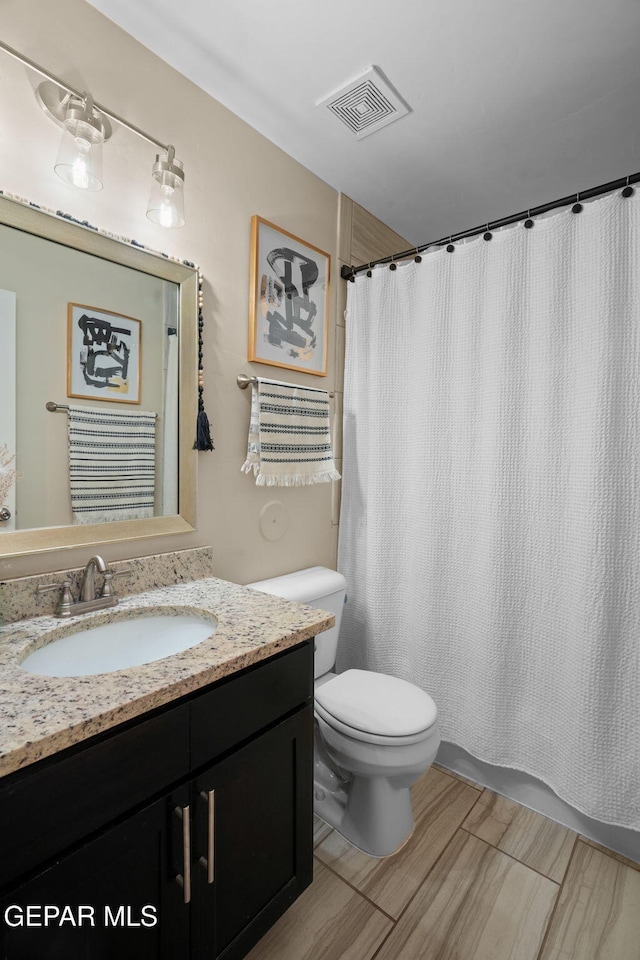 full bath featuring toilet, visible vents, vanity, and a shower with curtain