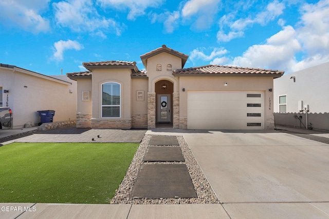 mediterranean / spanish house with stucco siding, a garage, driveway, stone siding, and a front lawn