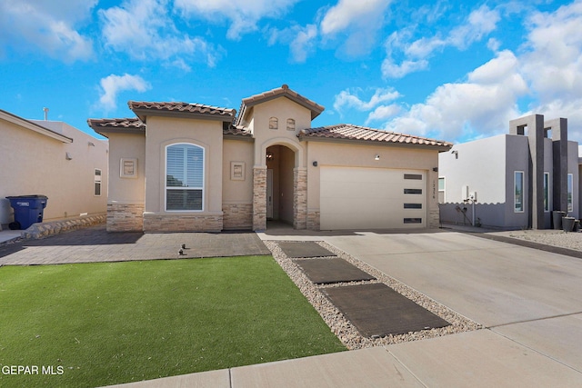 mediterranean / spanish home featuring driveway, a garage, stucco siding, stone siding, and a tile roof