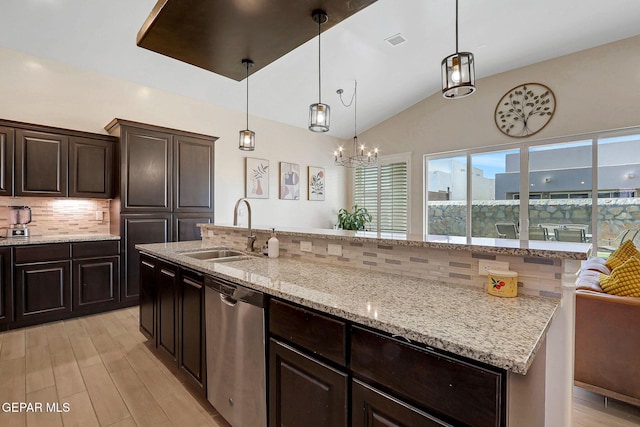 kitchen featuring a sink, dishwasher, backsplash, light wood-style floors, and lofted ceiling