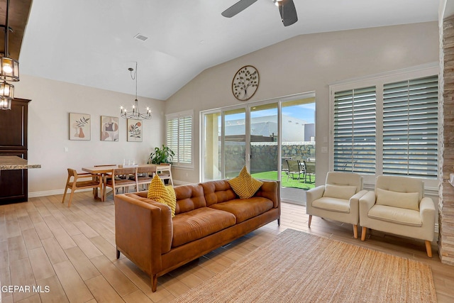 living area featuring lofted ceiling, light wood-style floors, ceiling fan, a chandelier, and baseboards