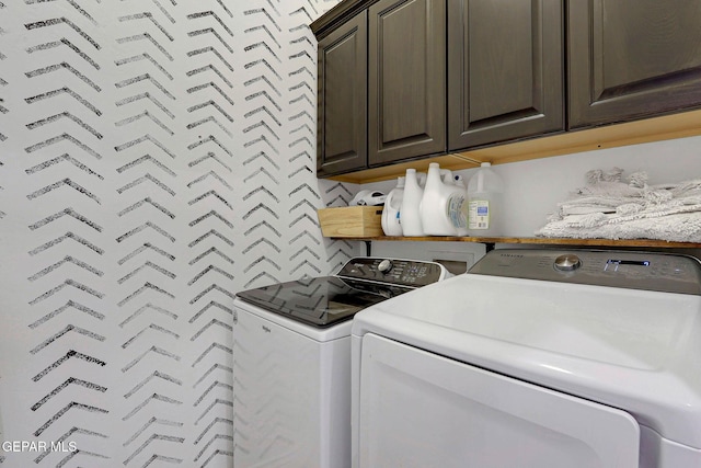 washroom featuring cabinet space and separate washer and dryer
