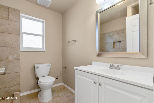 bathroom featuring toilet, vanity, tile patterned flooring, and baseboards
